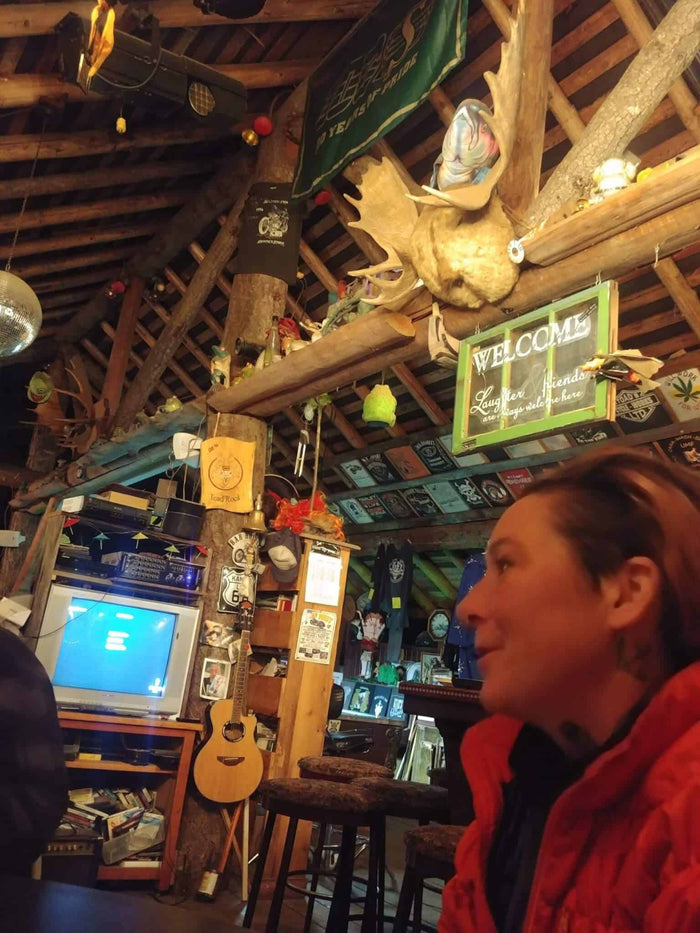 Rustic timber common room at Toad Rock moto campground with moose antlers and a Welcome sign