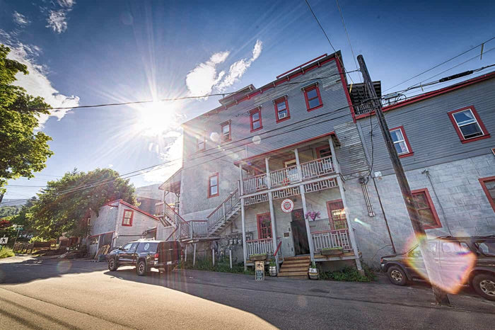 Nelson Brewing Company's metal-clad building with red trim and sun flare overhead