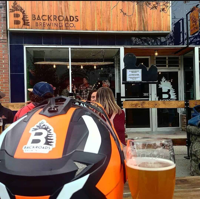 Backroads Brewing Co. patio in Nelson BC seen past an adventure motorcycle helmet and a glass of beer