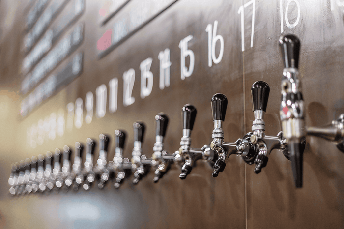 Close-up of Torchlight Brewing's stainless tap wall with numbered draught taps