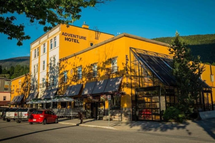 The bright yellow Adventure Hotel building with its greenhouse cafe in Nelson BC