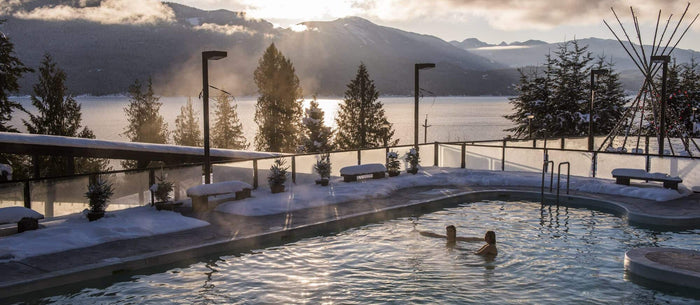 Steaming outdoor hot springs pool at Ainsworth Hot Springs overlooking Kootenay Lake at sunset