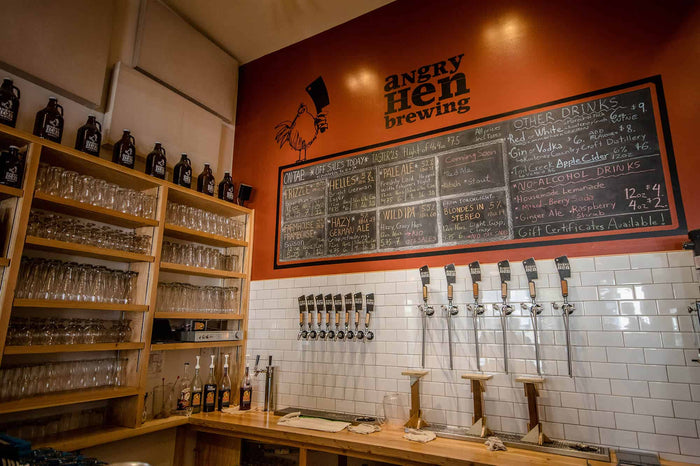 Angry Hen Brewing taproom in BC with growlers on shelves, a chalkboard menu and a row of beer taps