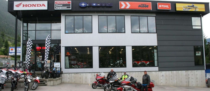 Mainjet Motorsports dealership exterior with Honda and KTM signage and riders parked out front