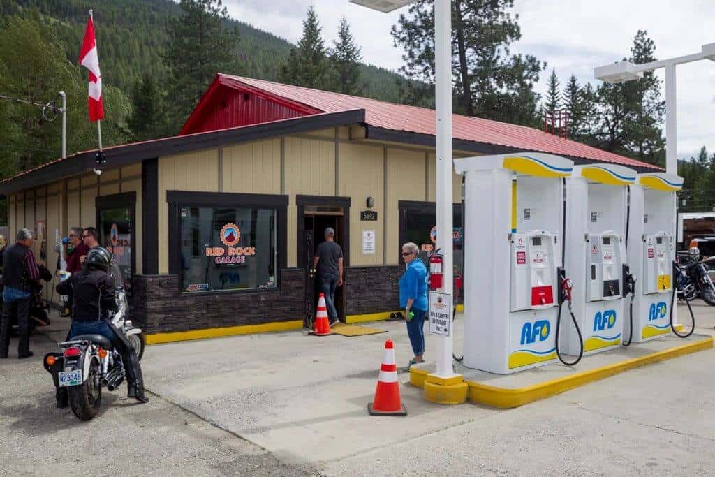 Red Rock Garage fuel station with pumps and a rider on a motorcycle pulling in