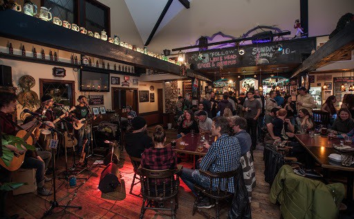 Live acoustic band playing to a packed crowd inside the rustic Lions Head Pub