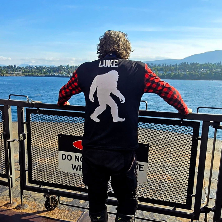 Back of the ITWMAT Lumbersquatch jersey with white Bigfoot graphic and LUKE name, worn at a BC ferry railing