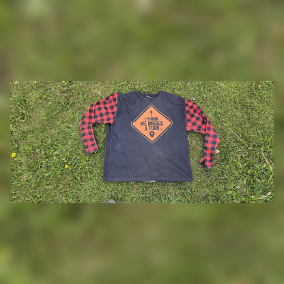 Front of the ITWMAT Lumbersquatch ADV jersey, black body with orange diamond logo and red plaid sleeves on grass