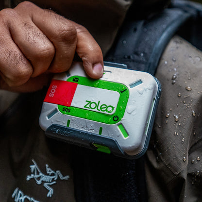 ZOLEO ZL1500 in hand, wet, clipped to a jacket strap