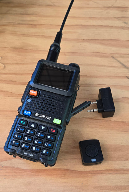 Baofeng UV-5RH radio on a wood table with antenna adapter and remote button